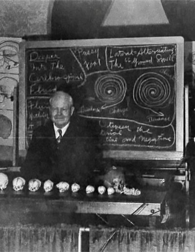Dr. William Garner Sutherland stands in front of a chalkboard