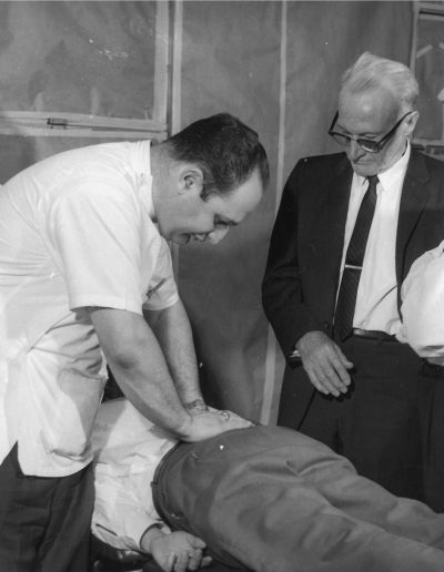Howard Lippincott, D.O., holds the lower spine of a man lying on a table