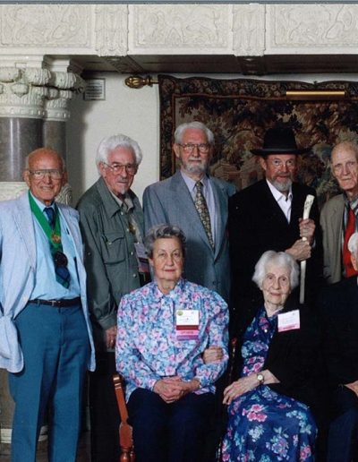 Two rows of OCA members, 7 men standing, two women, and one man sitting