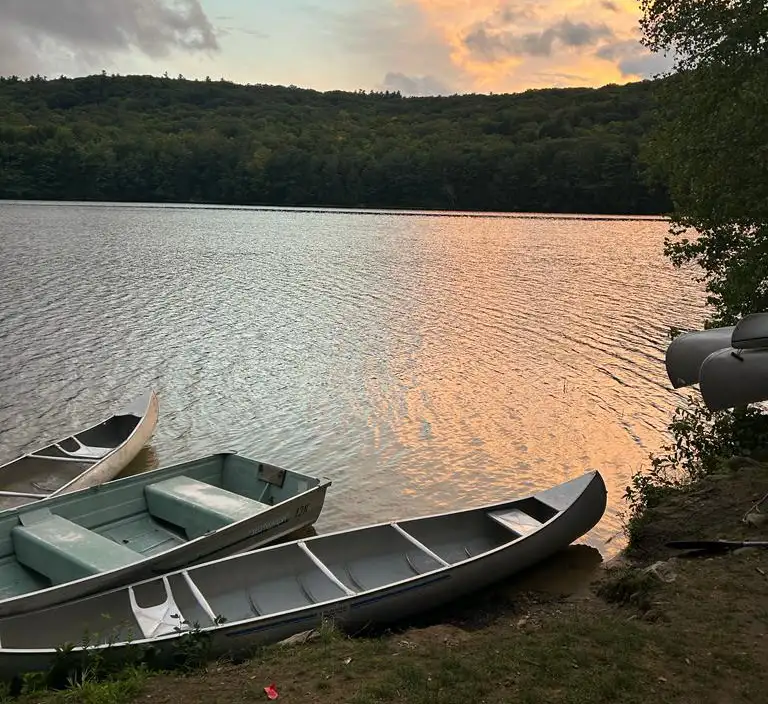 photo of lake at sunset with canoes in forground